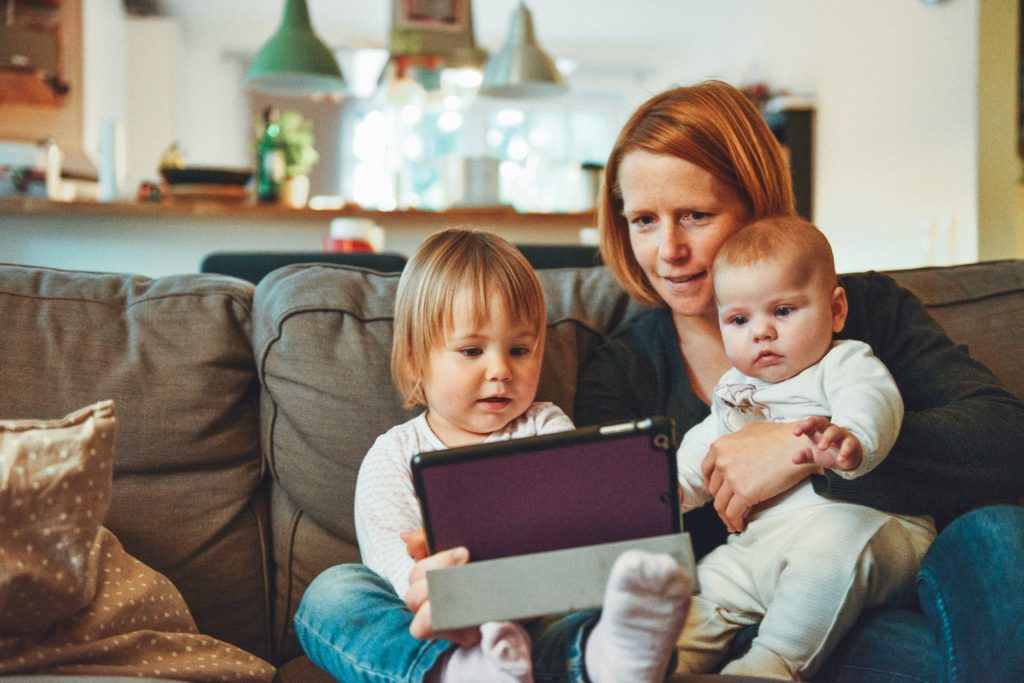 mom and small children looking at ipad family