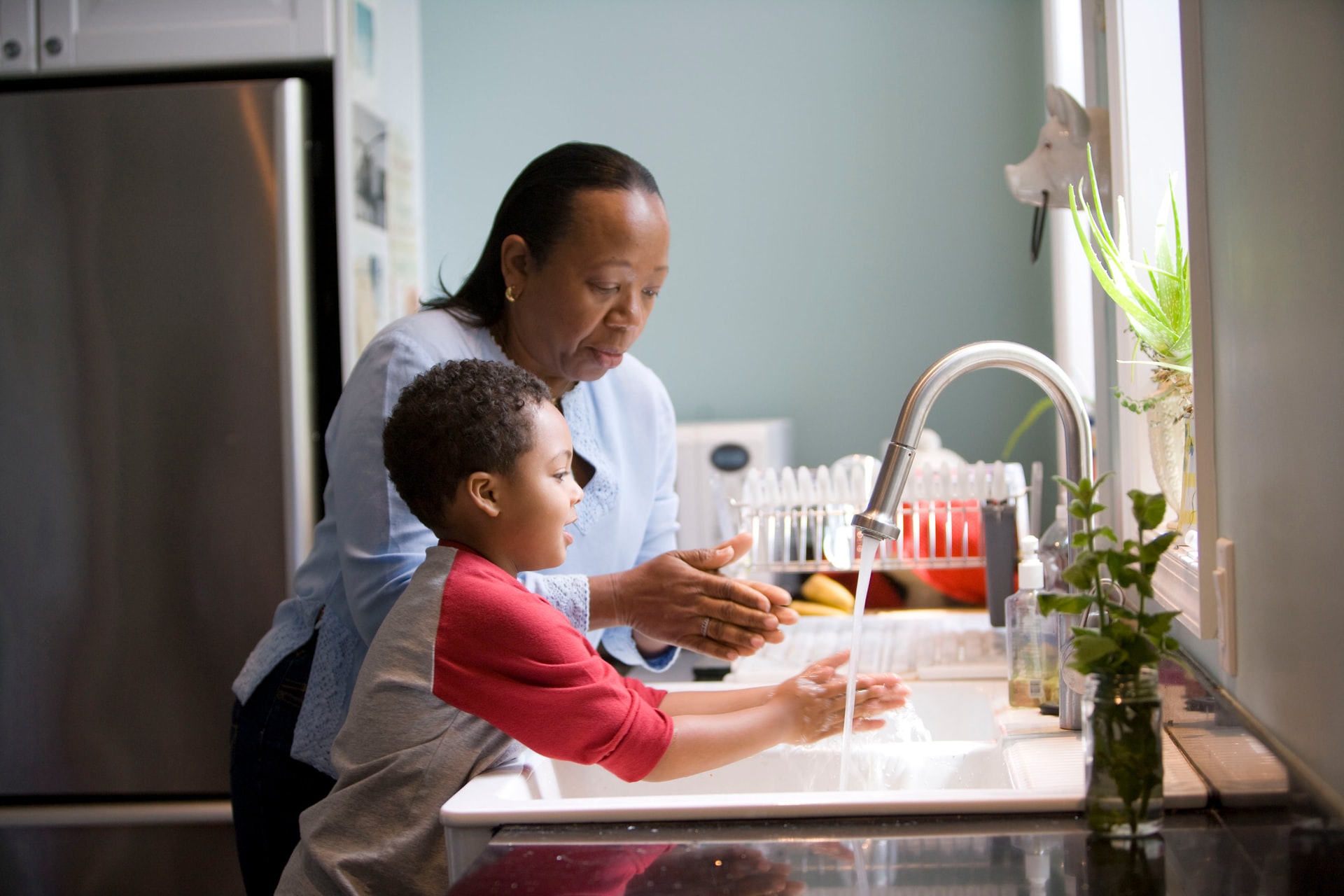 child washing hands with grandma